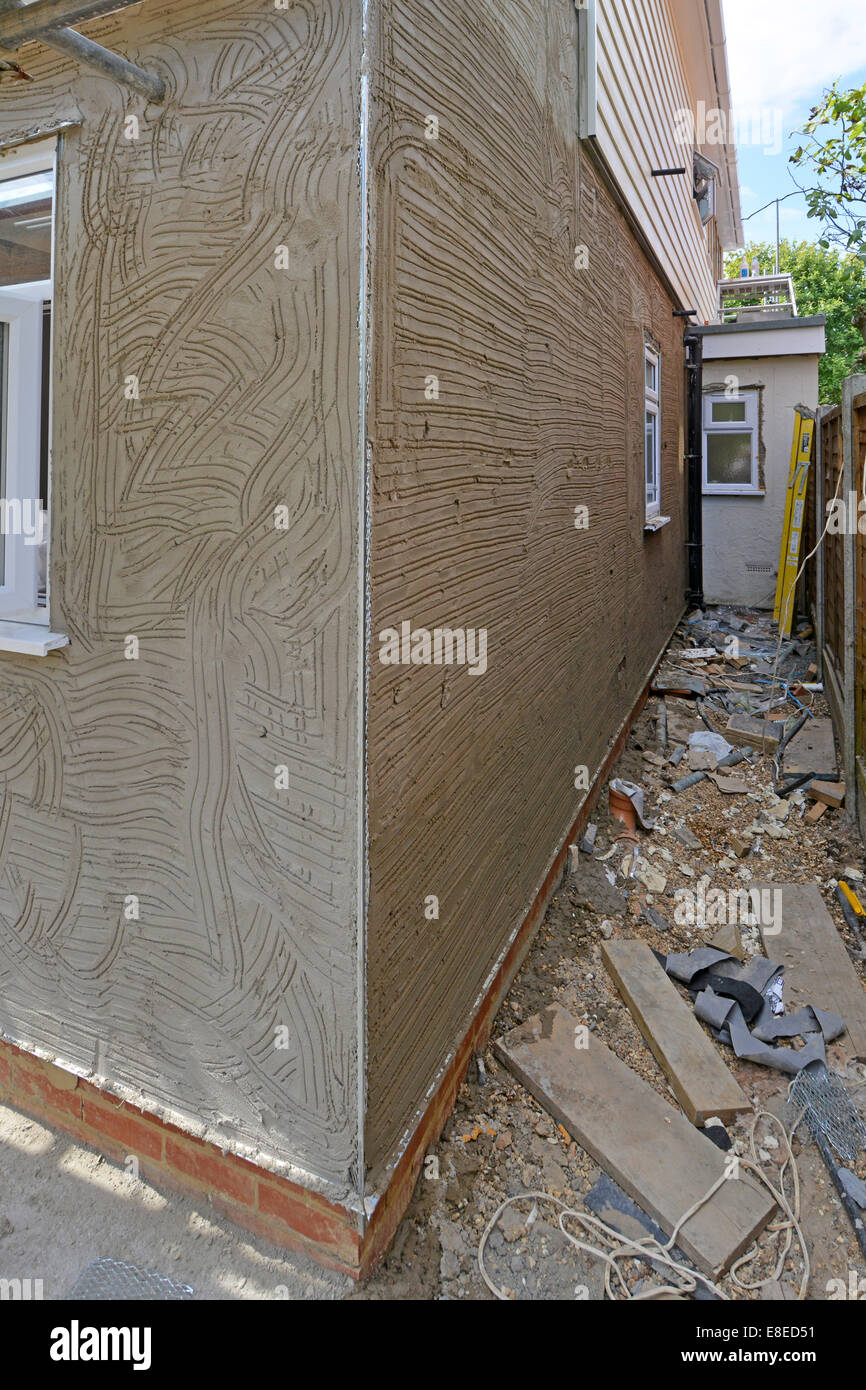 Cement sand rendering scratch coat on house extension wall corner angle bead & drip bead see 'More Info' note below Brentwood Essex England UK Stock Photo