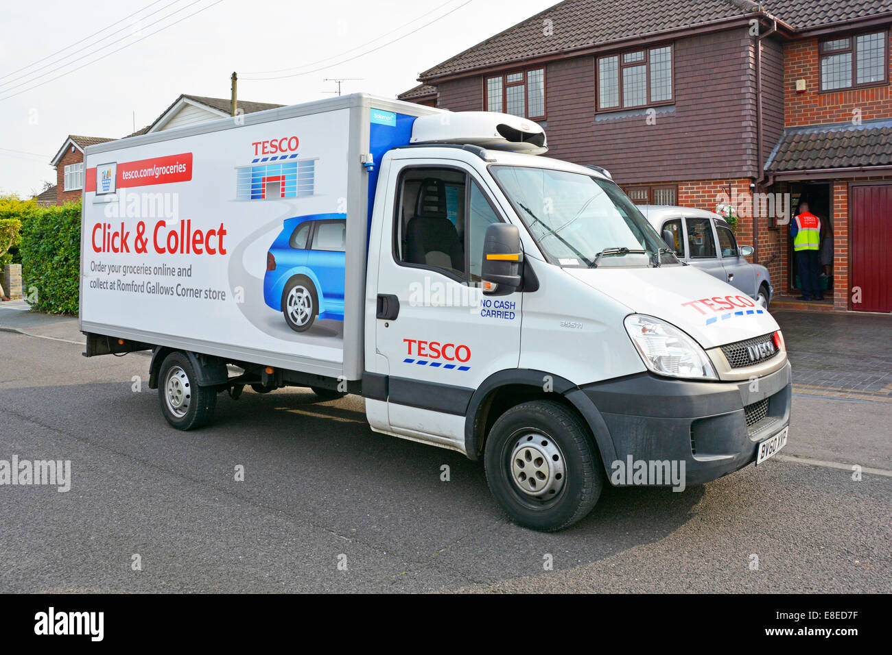 Click and Collect advert on Tesco home delivery van with driver at front door Stock Photo