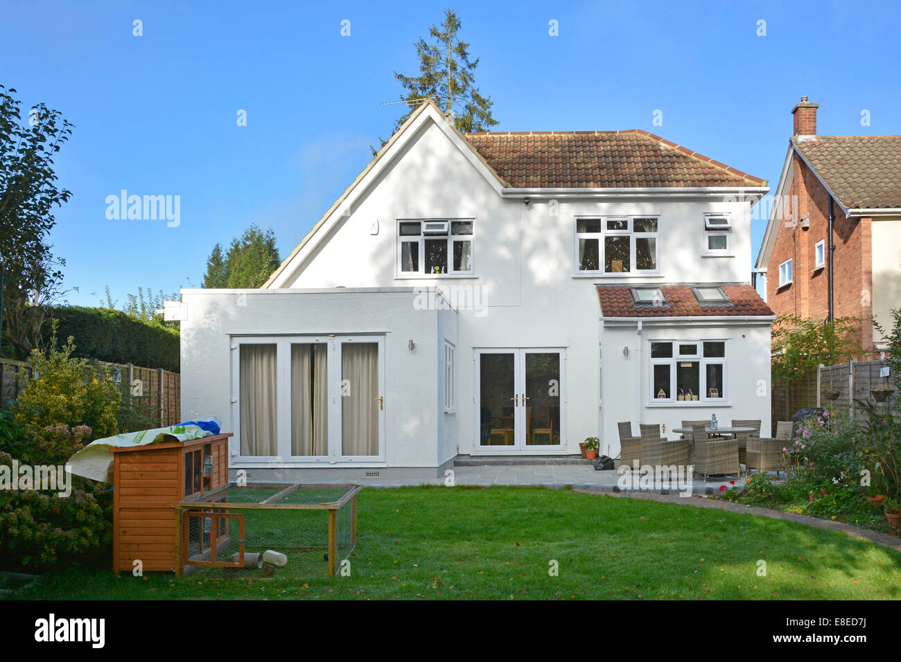 Completed two storey detached house side extension roof works & patio from back garden Essex England UK see 'More Info' note below Stock Photo