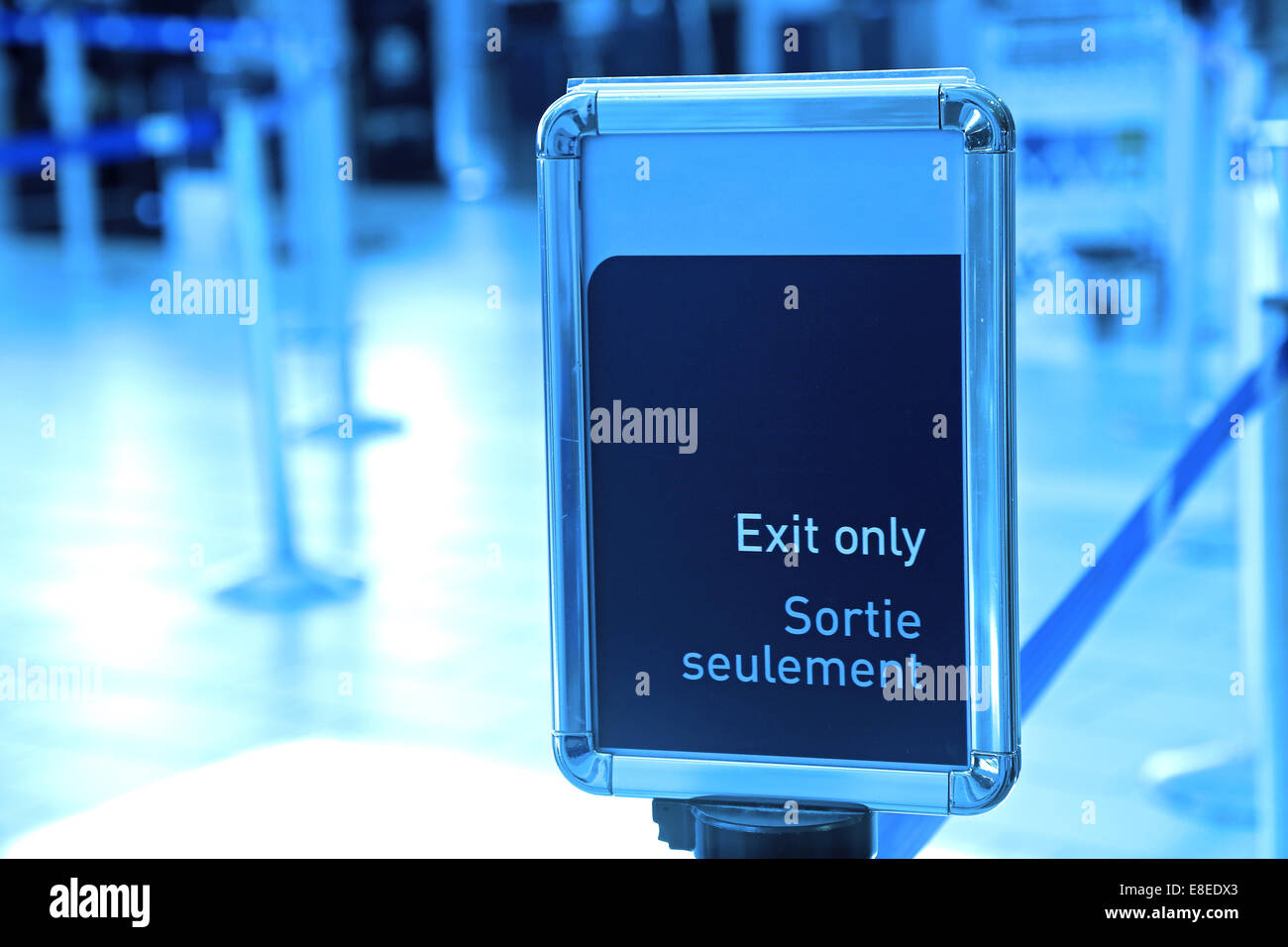 Exit sign in an airport with blue toned Stock Photo