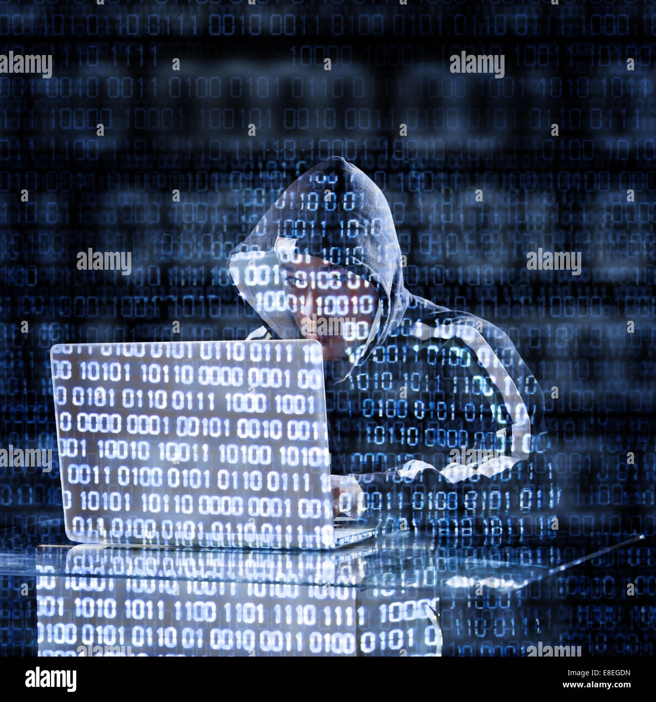 Hacker typing on a laptop with binary code in background Stock Photo