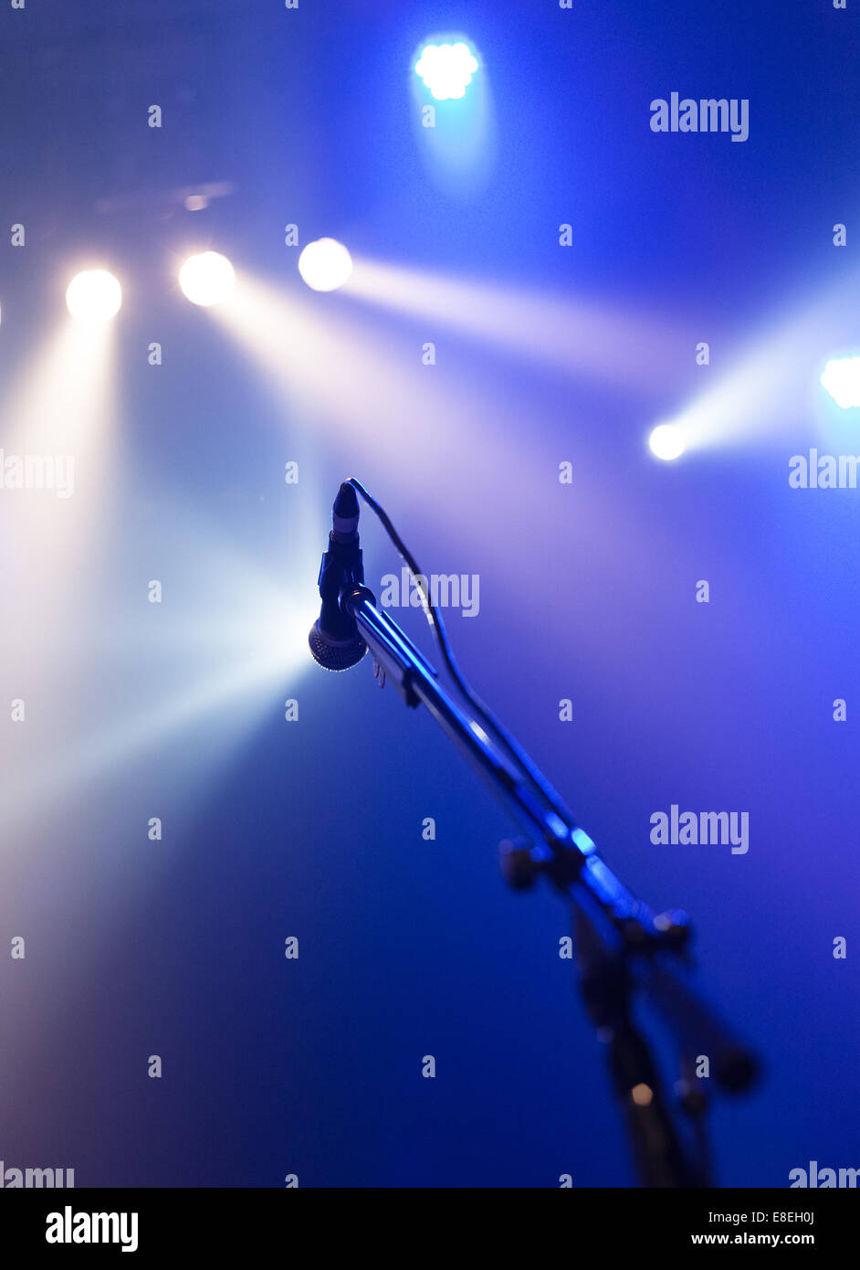 Microphone on empty stage waiting for a voice with copyspace and back light Stock Photo