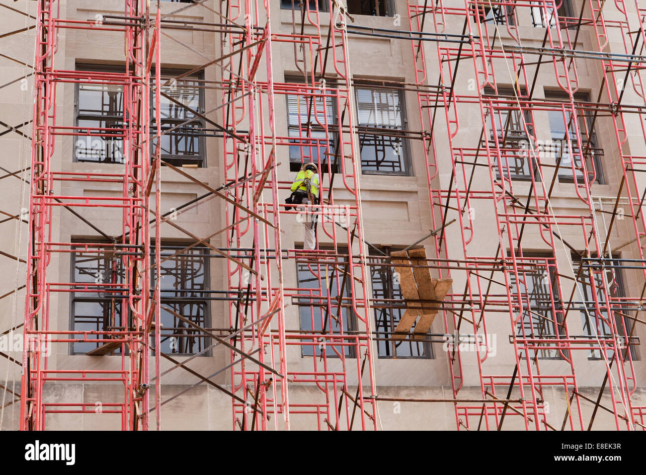 Construction worker climbing scaffolding - USA Stock Photo
