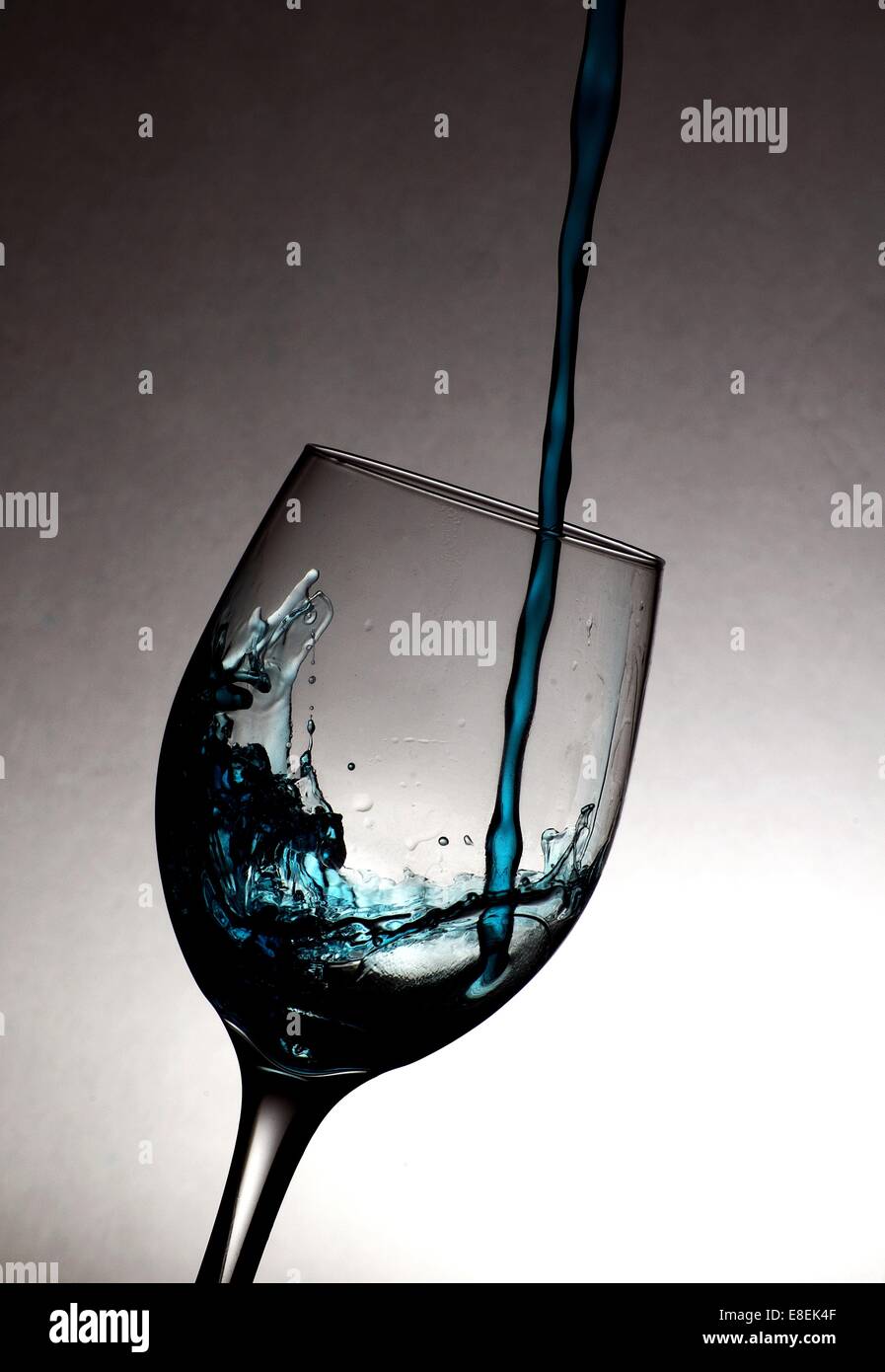 blue liquid pouring into a wine glass Stock Photo Alamy