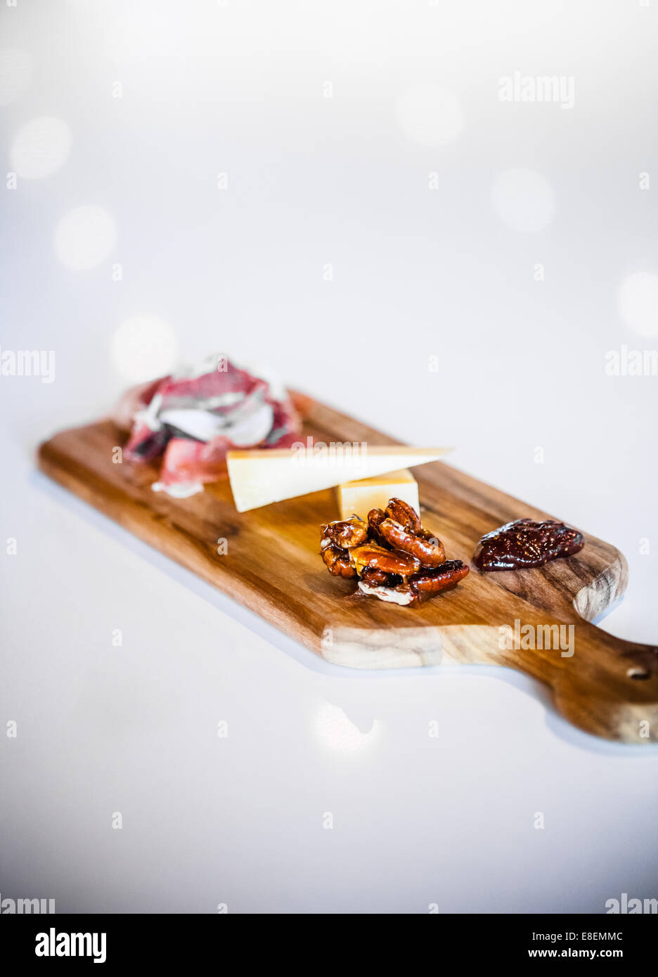 Traditional Portuguese Cheese Platter with Pecans and Prosciutto on a white Counter Stock Photo