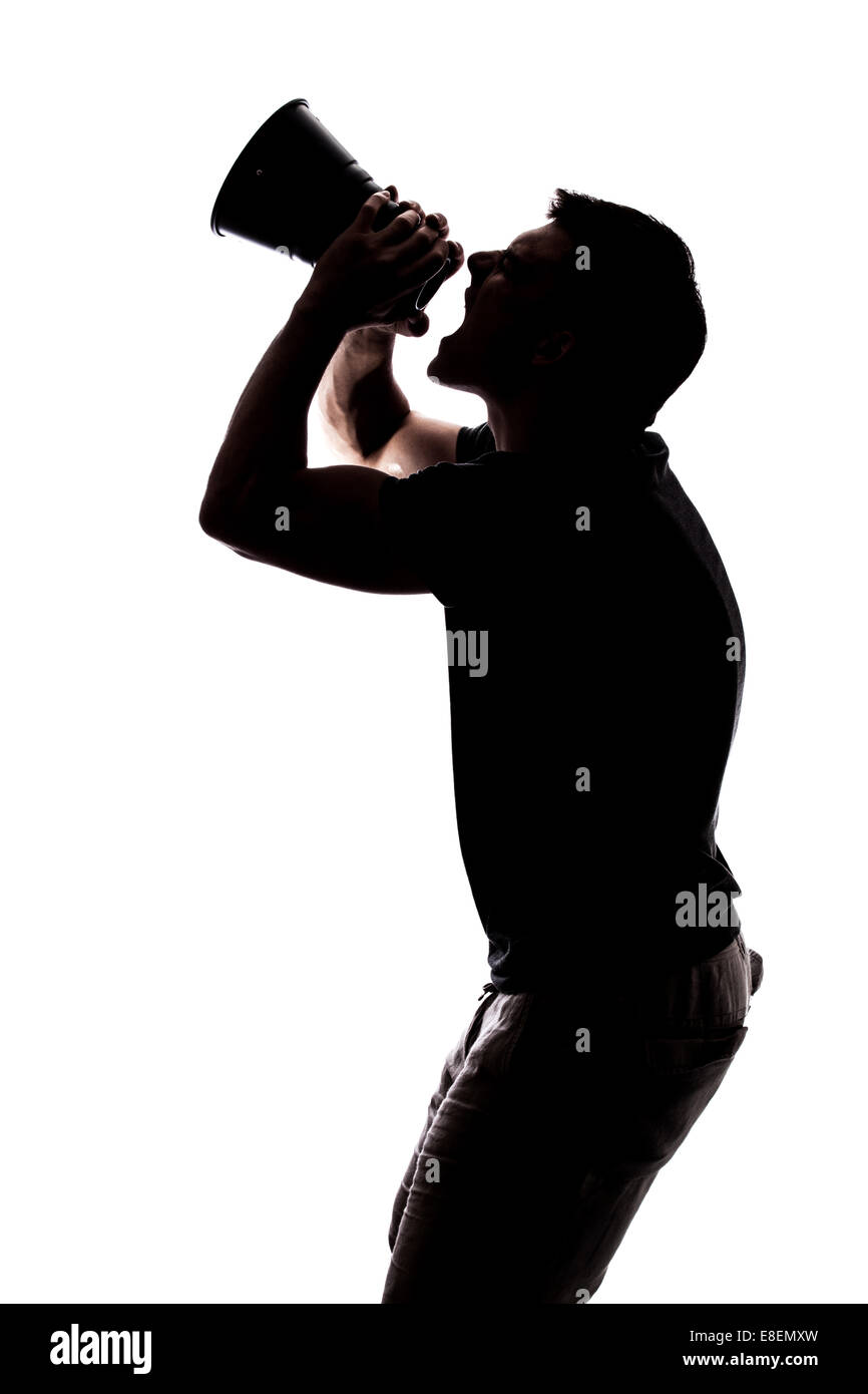 Man yelling in a megaphone in silhouette isolated over white background Stock Photo