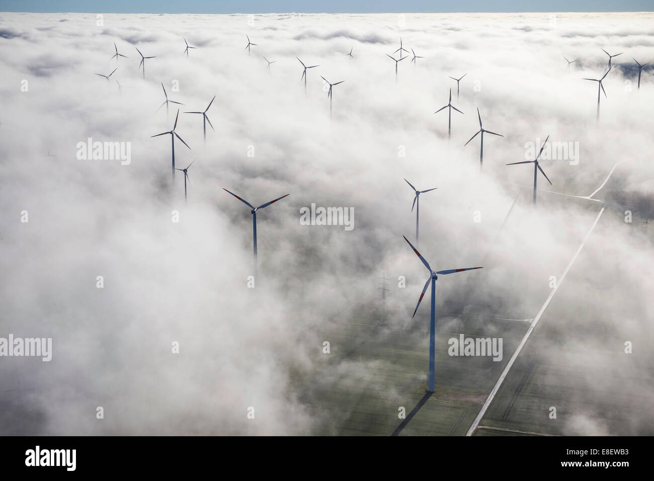 Wind turbines covered by low clouds, blue sky, aerial view, Marsberg, Sauerland region, North Rhine-Westphalia, Germany Stock Photo