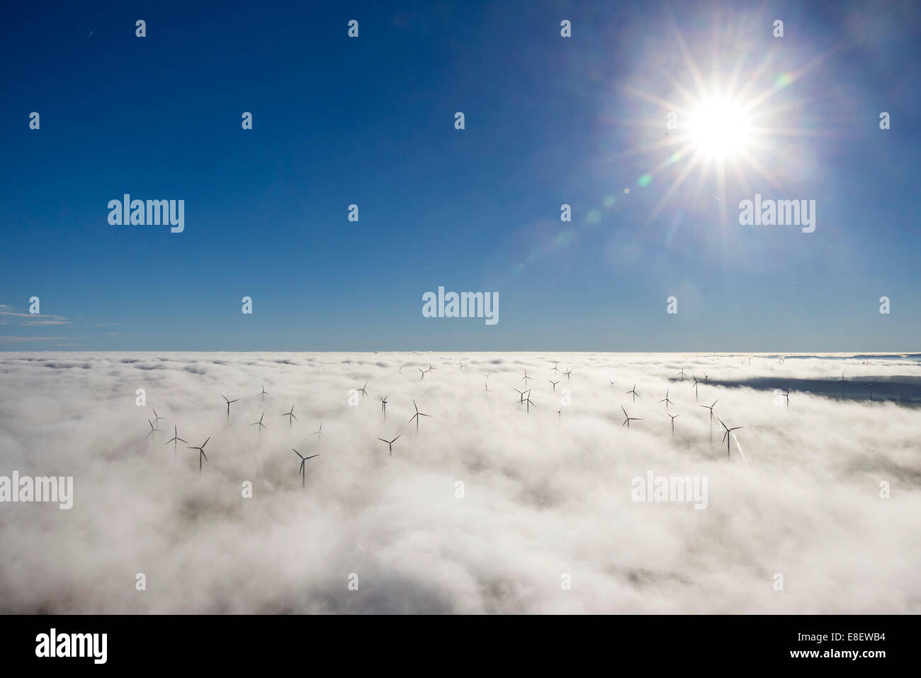 Wind turbines covered by low clouds, blue sky, aerial view, Marsberg, Sauerland region, North Rhine-Westphalia, Germany Stock Photo