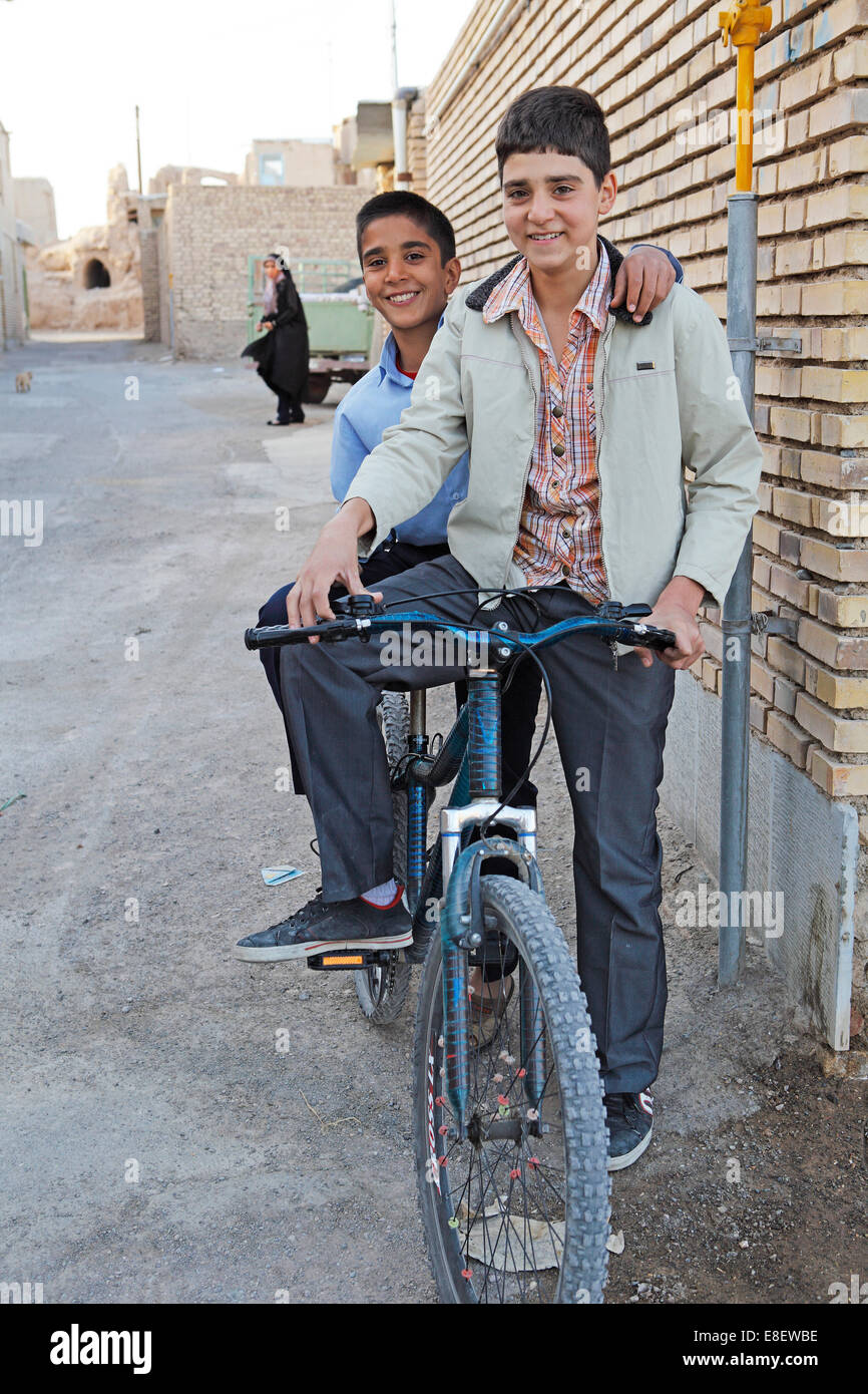 Boys with a bicycle in a residential alleyway, Na'in, Isfahan Province, Iran Stock Photo