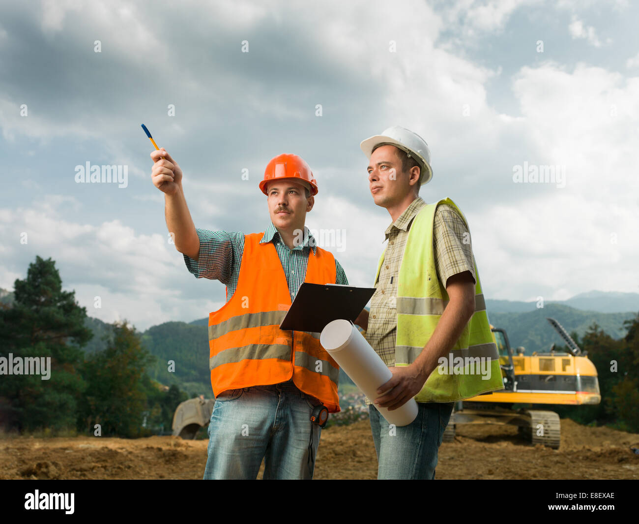 two coworkers on construction site outdoors discussing Stock Photo