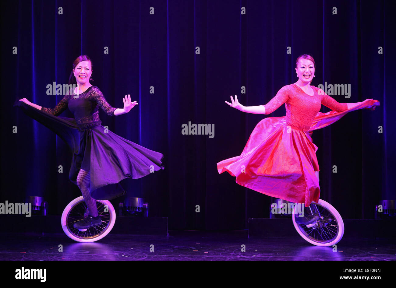 The unicycle artists Yuka & Satomi pose on their unicycles at the photo