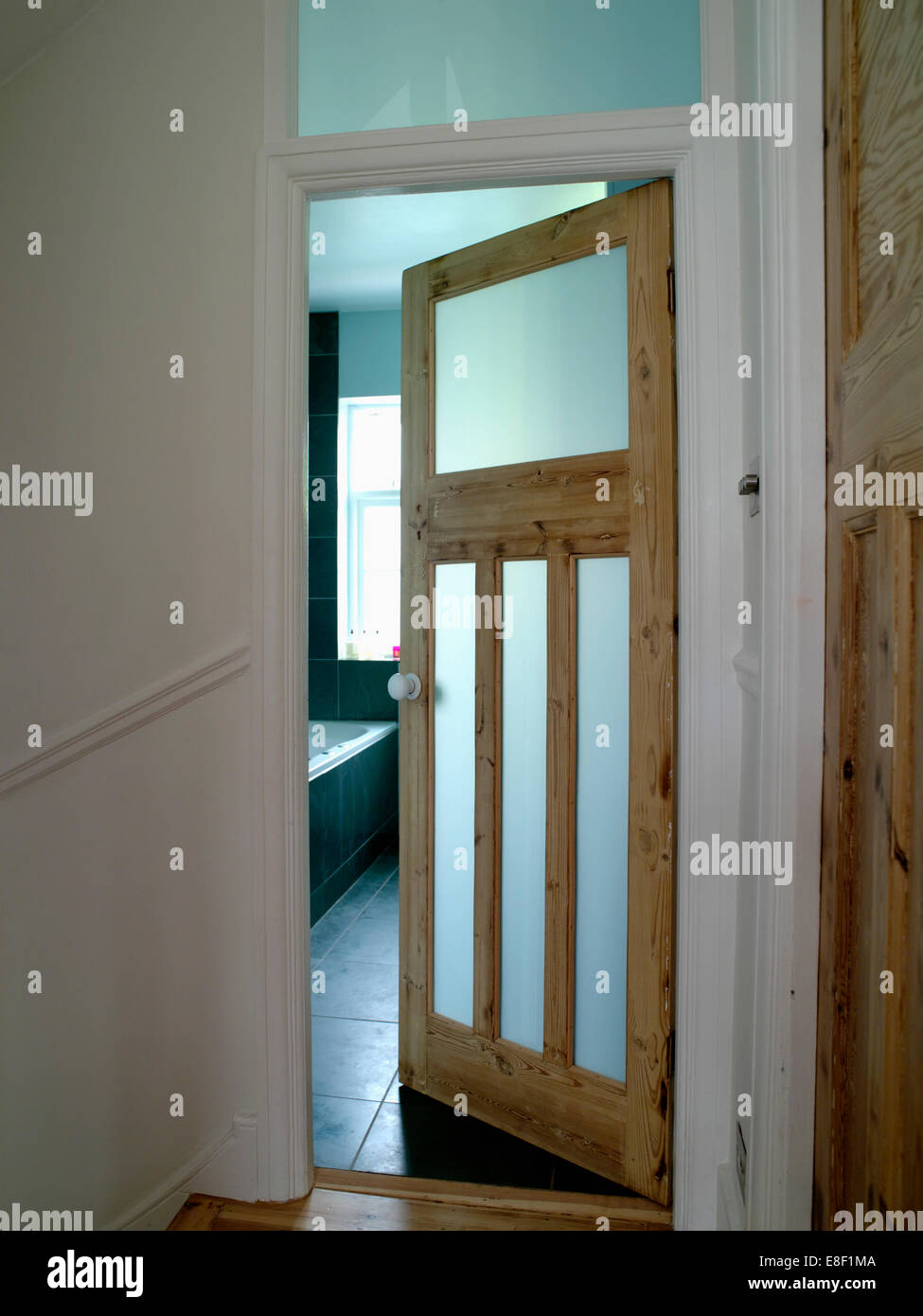 Open thirties style bathroom door with opaque glazed panels Stock Photo