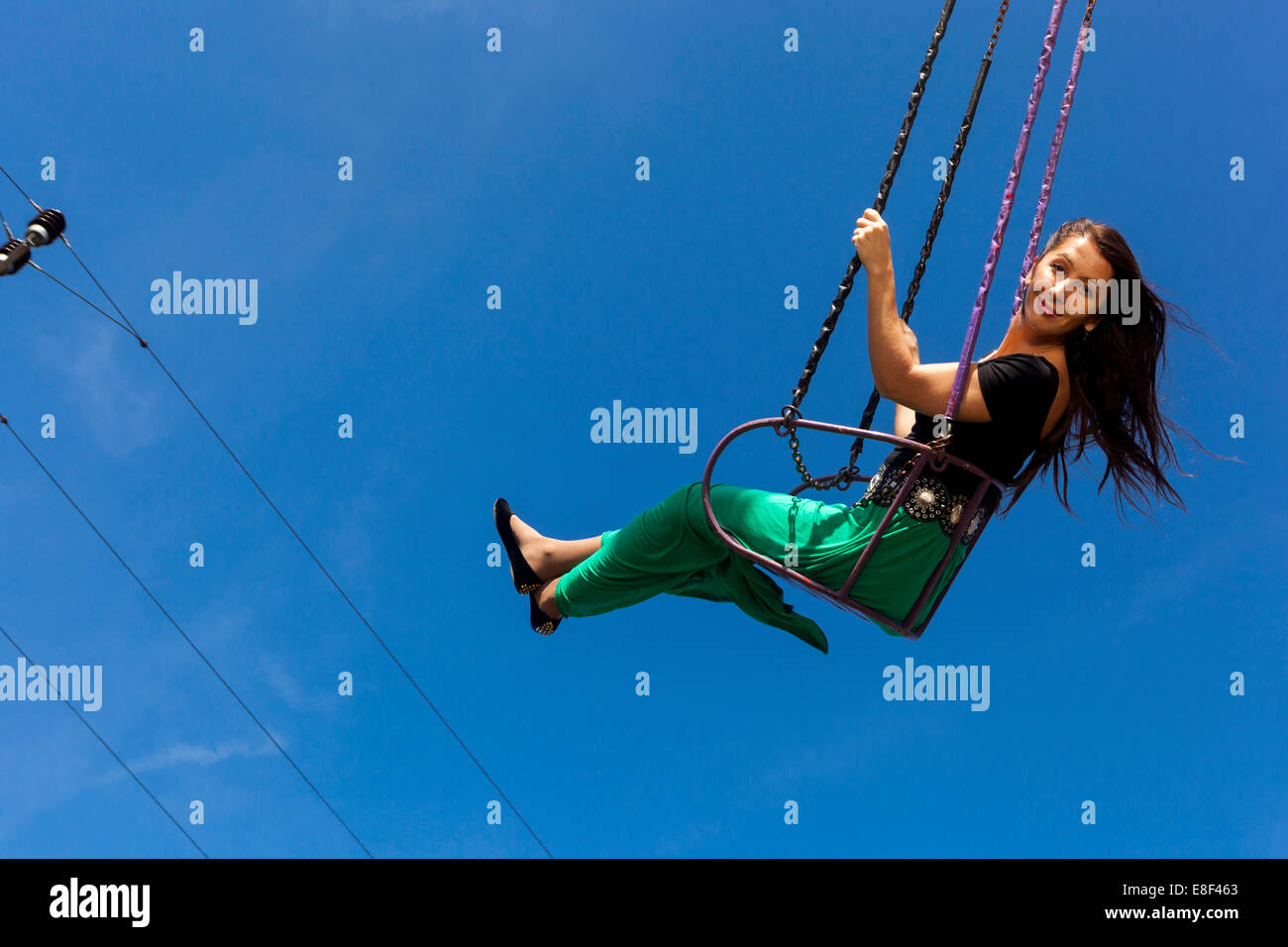 Young woman on the chain swing carousel Stock Photo
