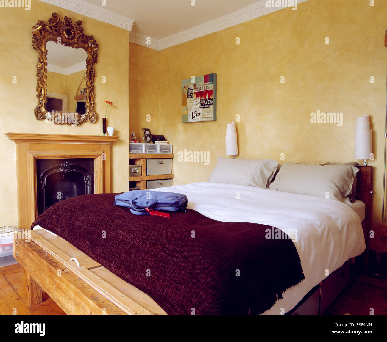 Purple Throw And White Duvet On Simple Wooden Bed In Economy