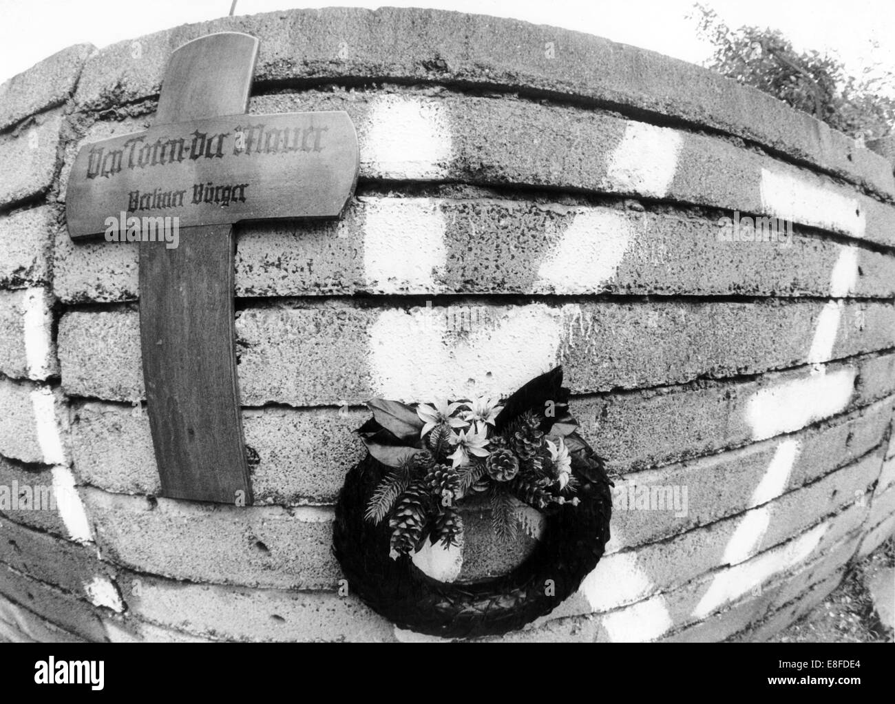A memorial cross and a wreath for the persons killed at the Berlin Wall can be seen on the 18th anniversary of the building of the Berlin Wall in Bernauer Street in Berlin on 11 August 1979. From 13 August 1961, the day of the building of the Berlin Wall, to the fall of the Berlin Wall on 9 November 1989, the Federal Republic of Germany and the GDR were separated by the Iron Curtain between  West and East. Stock Photo