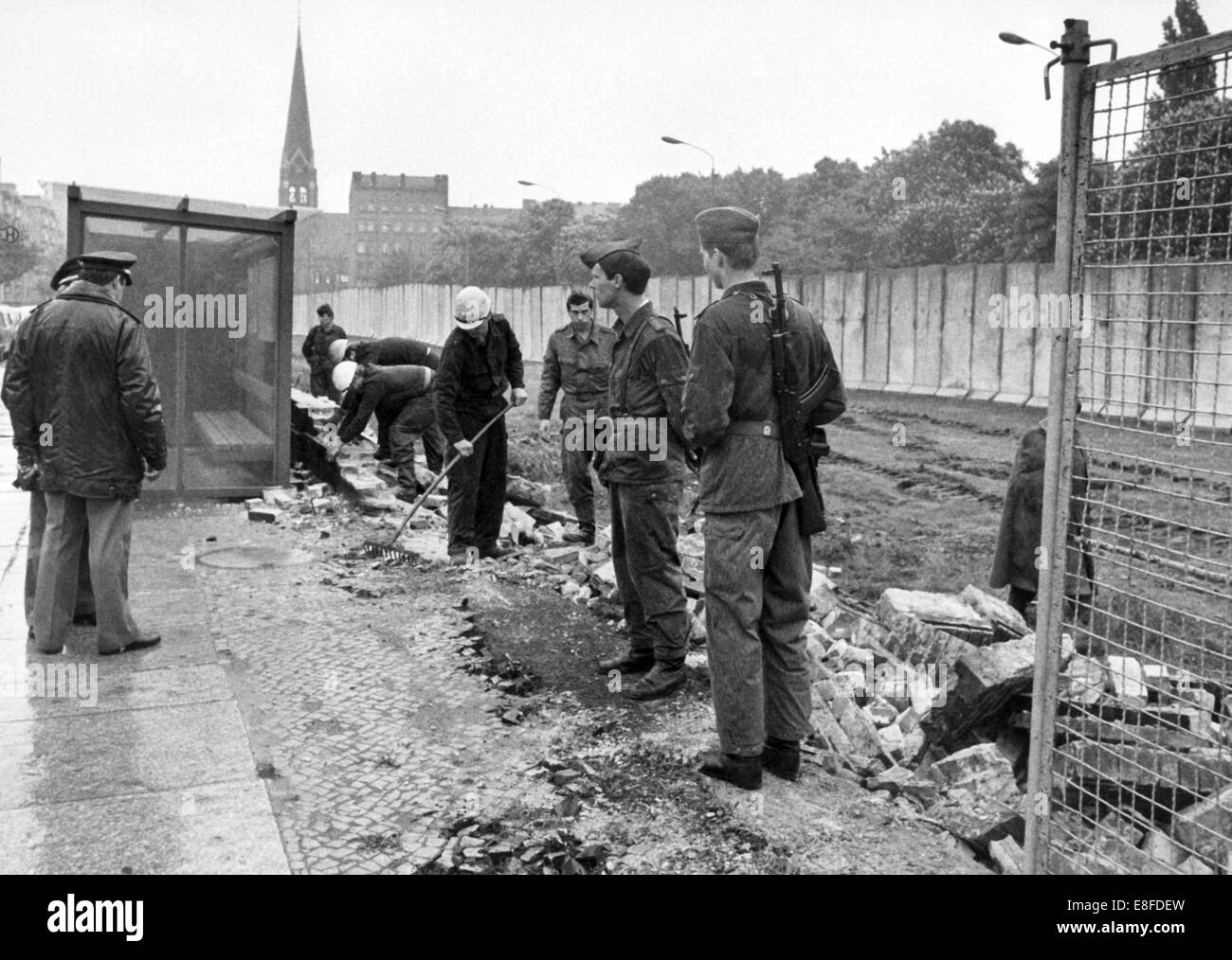 Workers from East Berlin have started to tear down the old wall and to replace it with a wire fence at Bernauer Street under the custody of the People's Police on the 29th of May in 1980. Stock Photo