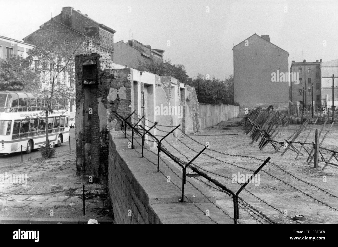 View on the Berlin Wall with separation barriers and death strips in the  Bernauer Straße in Berlin-Wedding on 22nd October 1965. Well identifiable  are the remains of the houses which were torn