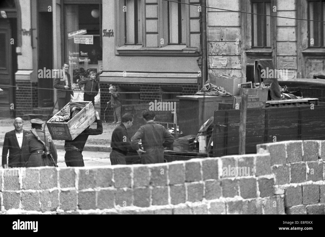 East Berlin evacuation commands carrying out the belongings of residents who live in the border houses on Bernauer Straße on the border between East and West Berlin on 14th October 1961. From the 13th August 1961, the day of the Berlin Wall construction, until the fall of the wall on 9th November 1989 the Federal Republik of Germany and the GDR were separated between west and east by an 'iron curtain'. Stock Photo