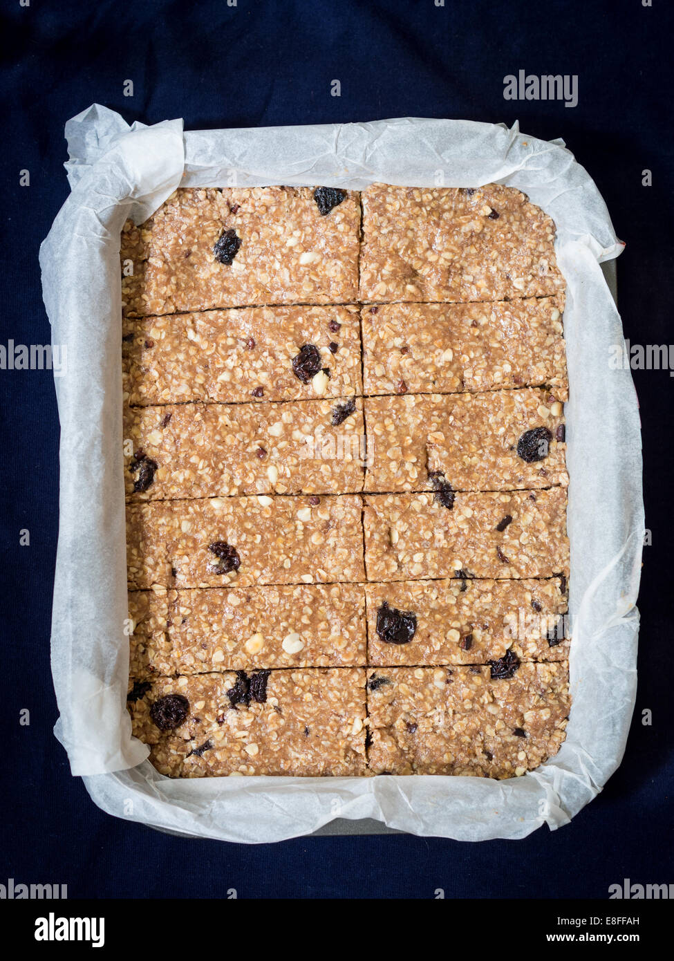 Homemade chewy granola (muesli) protein bars made of peanut butter, honey, nuts and raisins on a