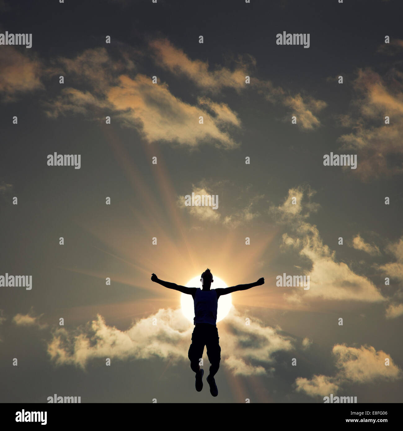 Silhouette of man jumping in front of the sun Stock Photo