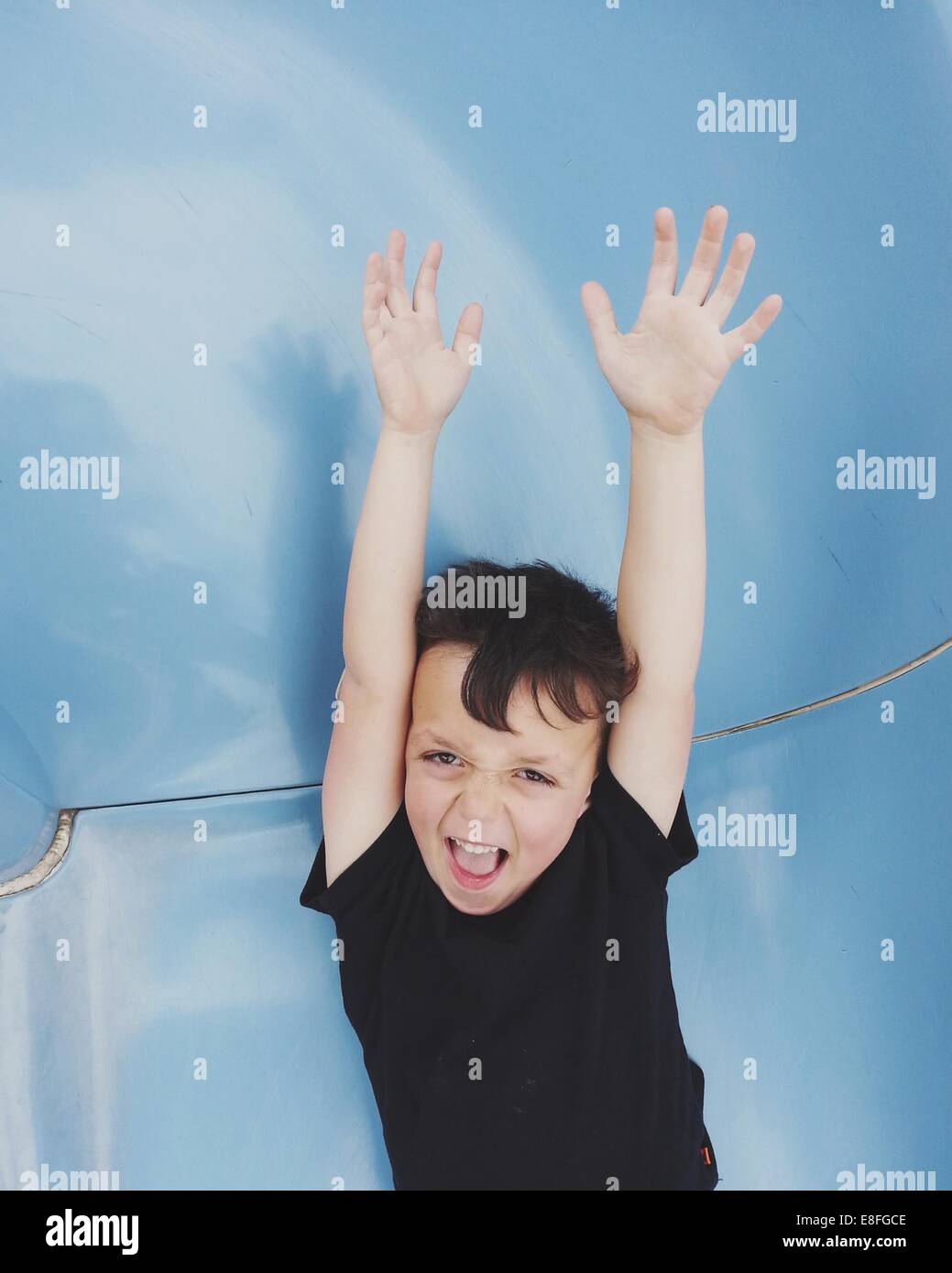 Boy standing with his arms in air Stock Photo