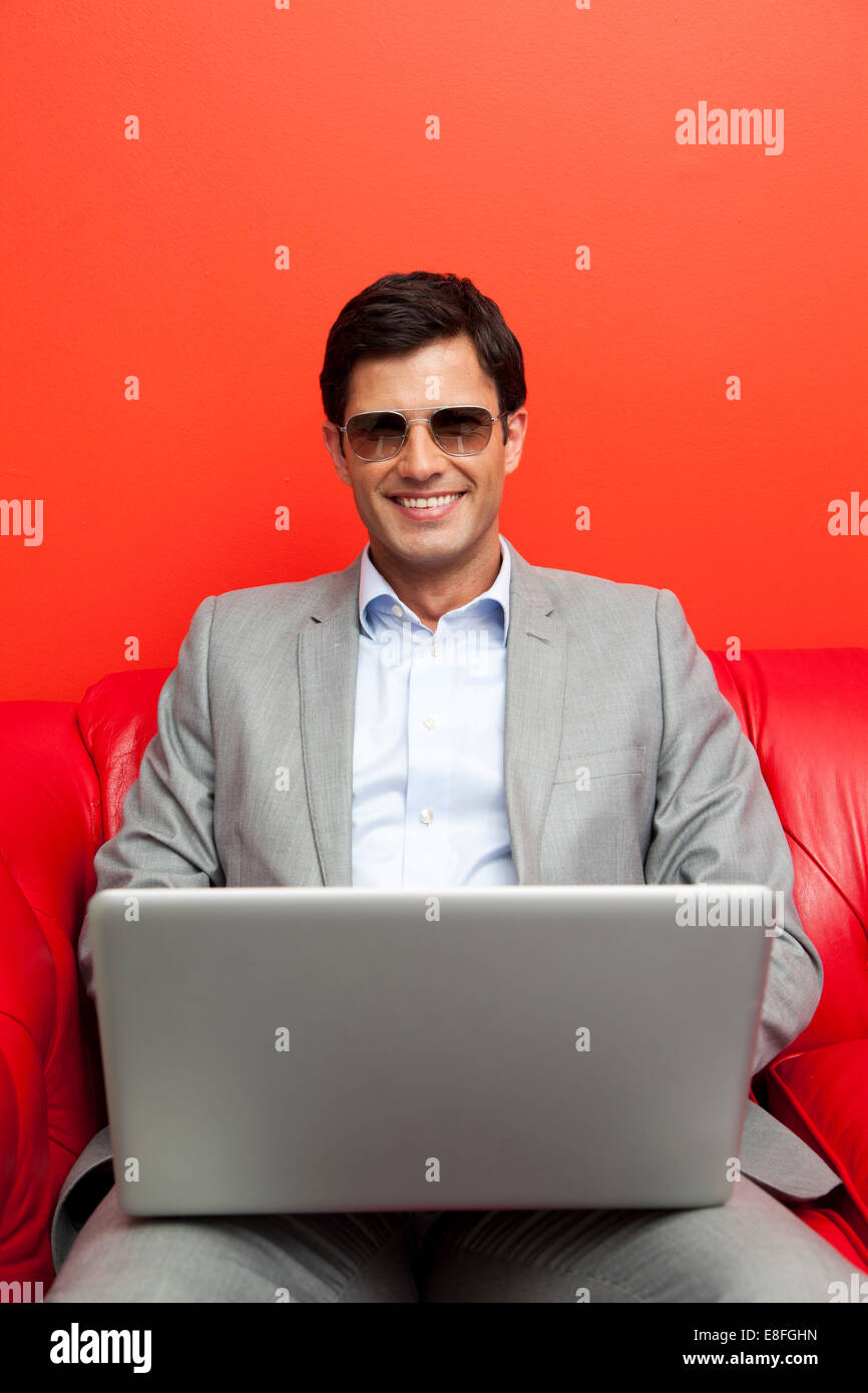 Portrait of a businessman using a laptop, wearing sunglasses Stock ...