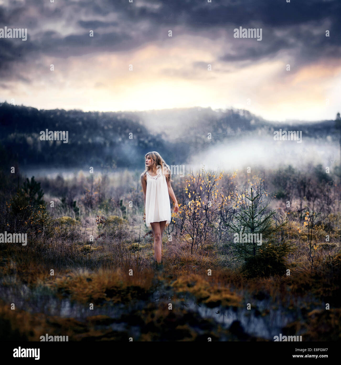 Woman walking through misty landscape, Norway Stock Photo