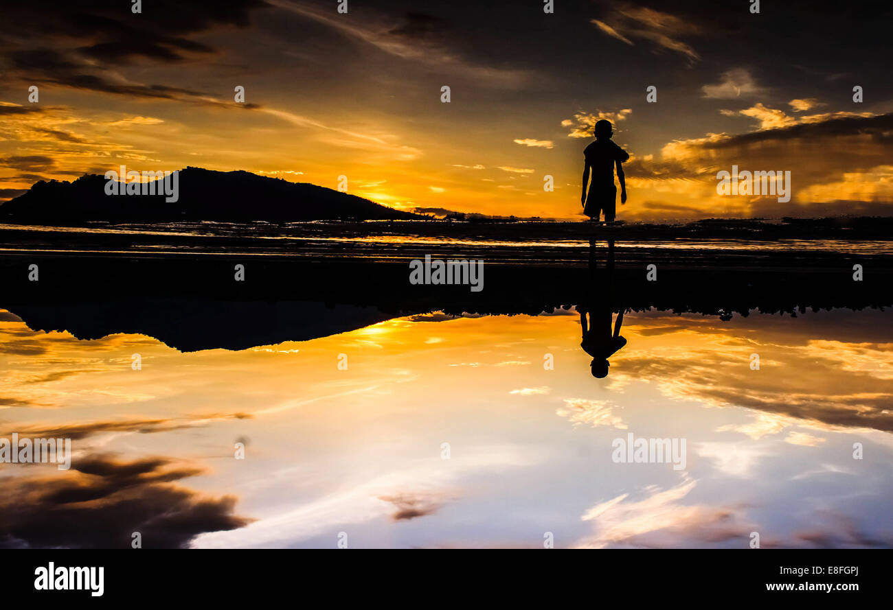 Silhouette of man standing on beach at sunset Stock Photo - Alamy