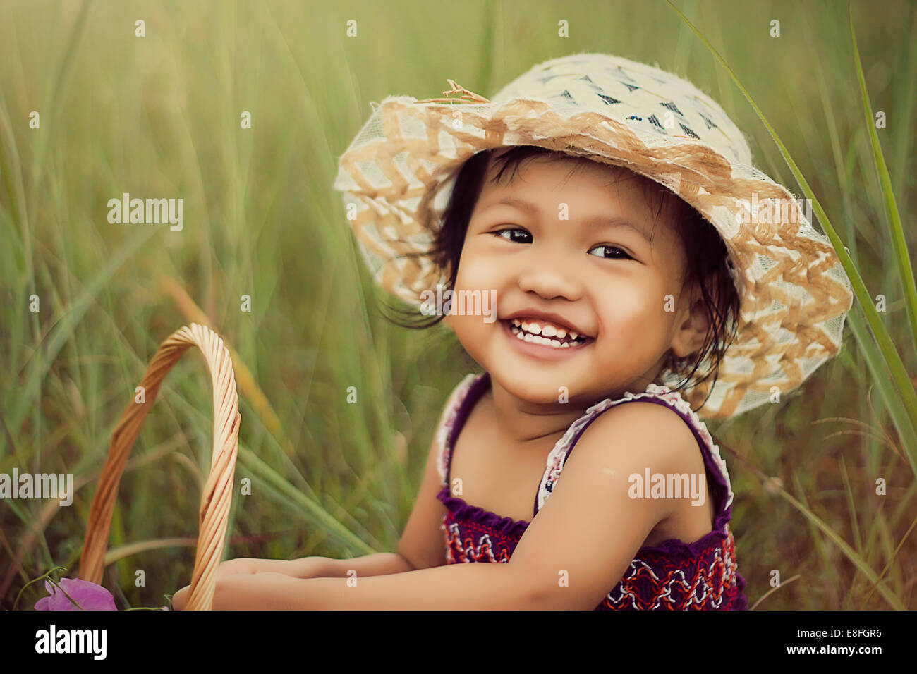 Portrait of smiling girl sitting in grass Stock Photo - Alamy