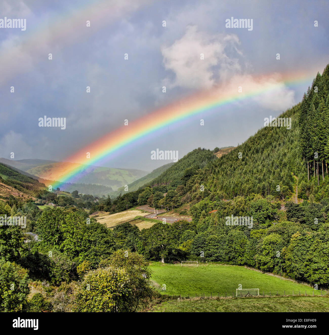 View of double rainbow above valley Stock Photo