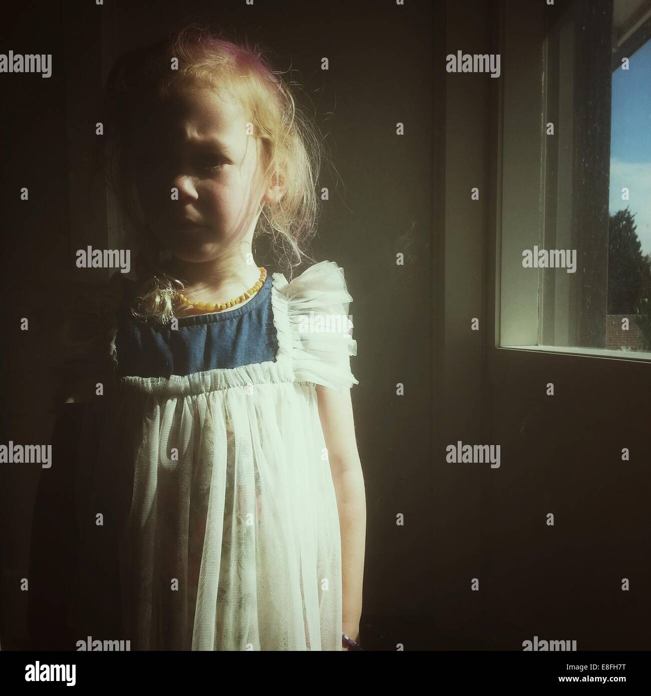 Portrait of a girl standing by a window Stock Photo