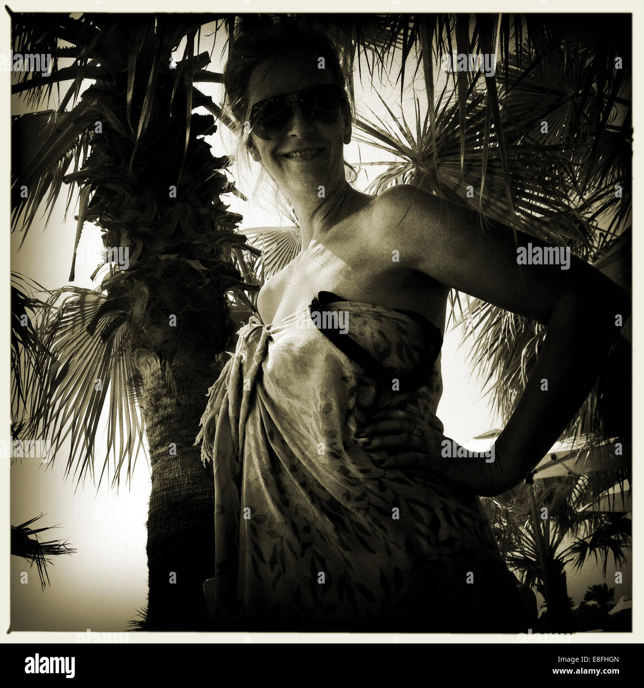 Portrait of woman under palm tree Stock Photo - Alamy