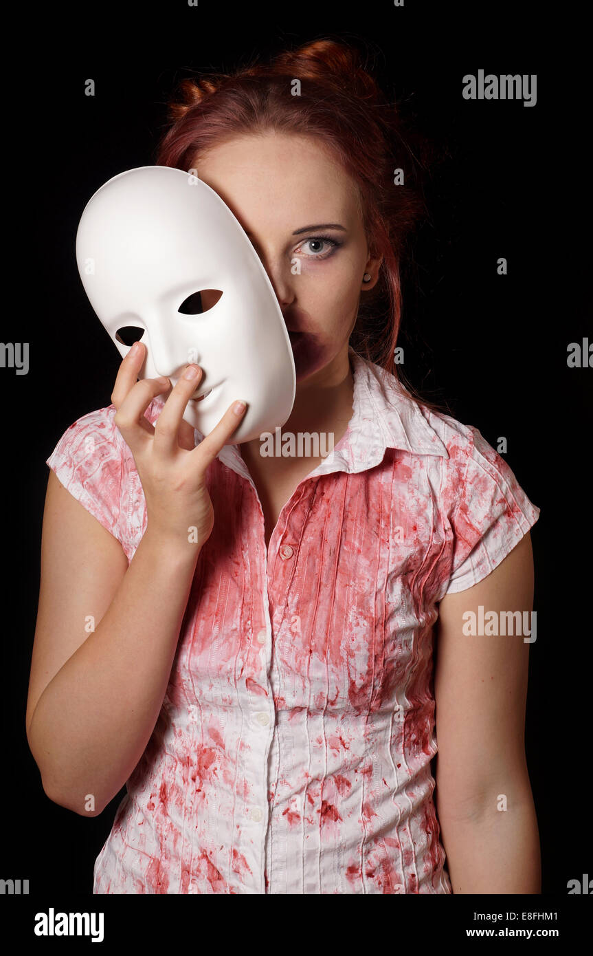 female zombie with halloween mask and bloody shirt Stock Photo