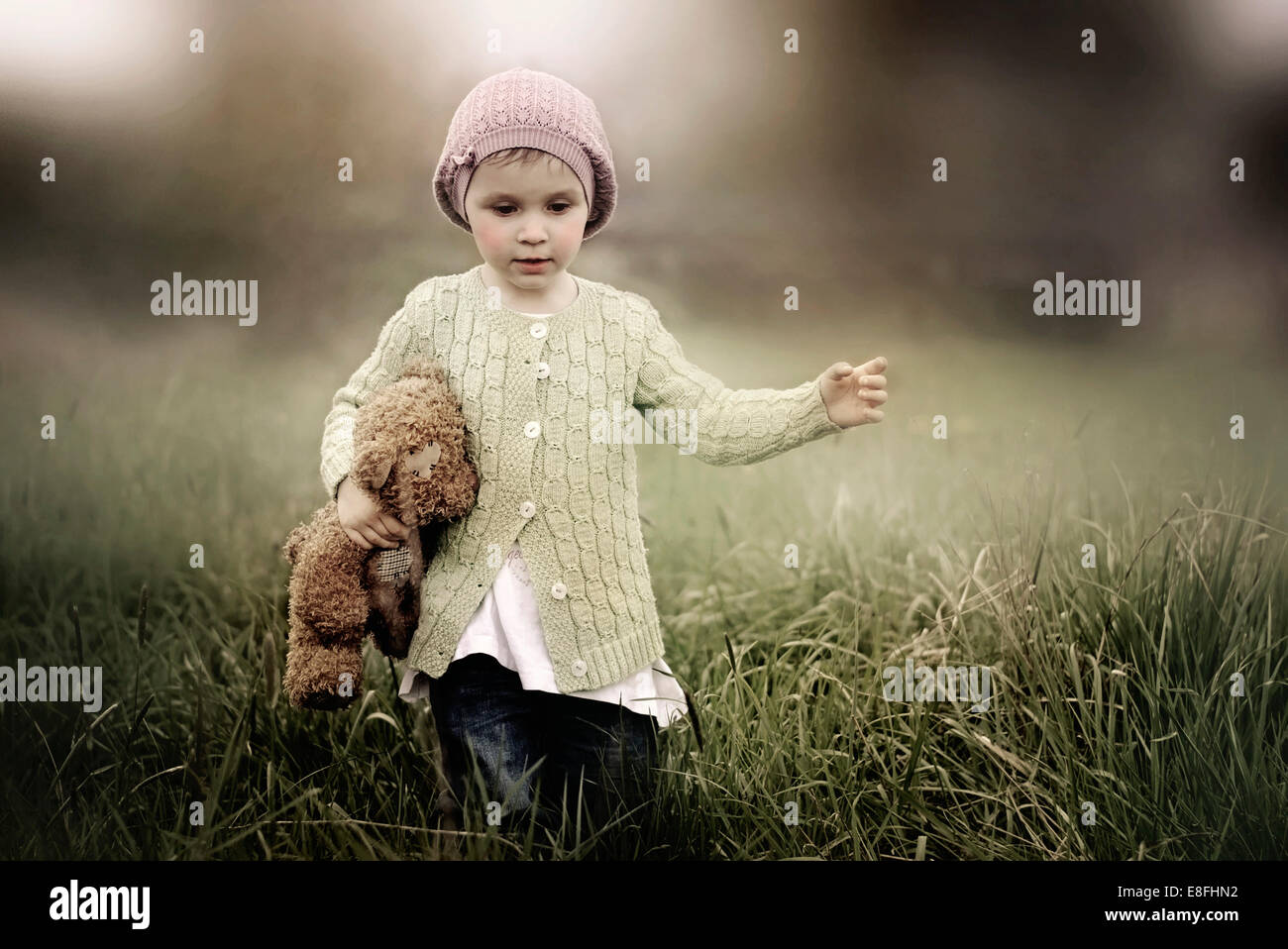 Girl holding teddy while running Stock Photo