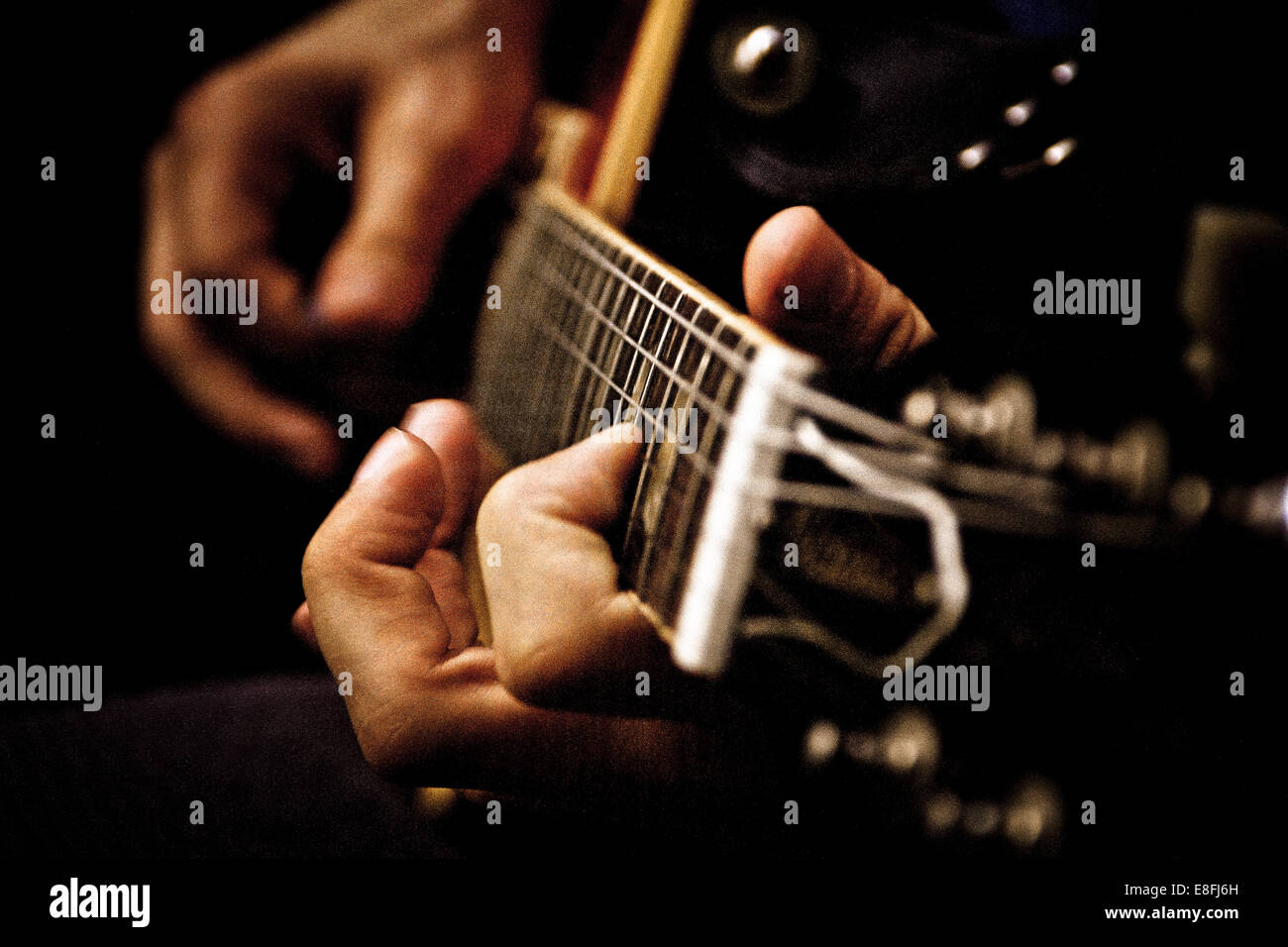 Close up of young man playing acoustic guitar Stock Photo