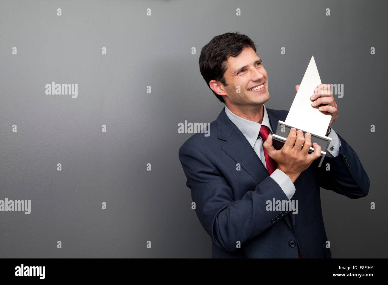 Businessman holding trophy Stock Photo - Alamy