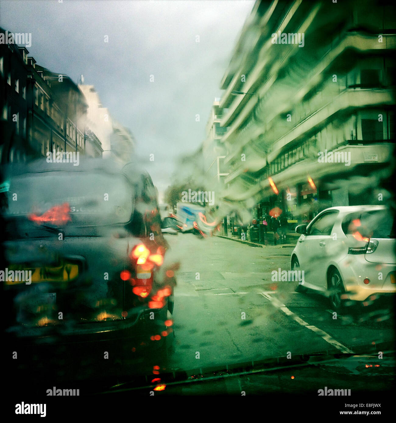 UK, London, Westminster, Knightsbridge, Taxi and car in wet weather Stock Photo