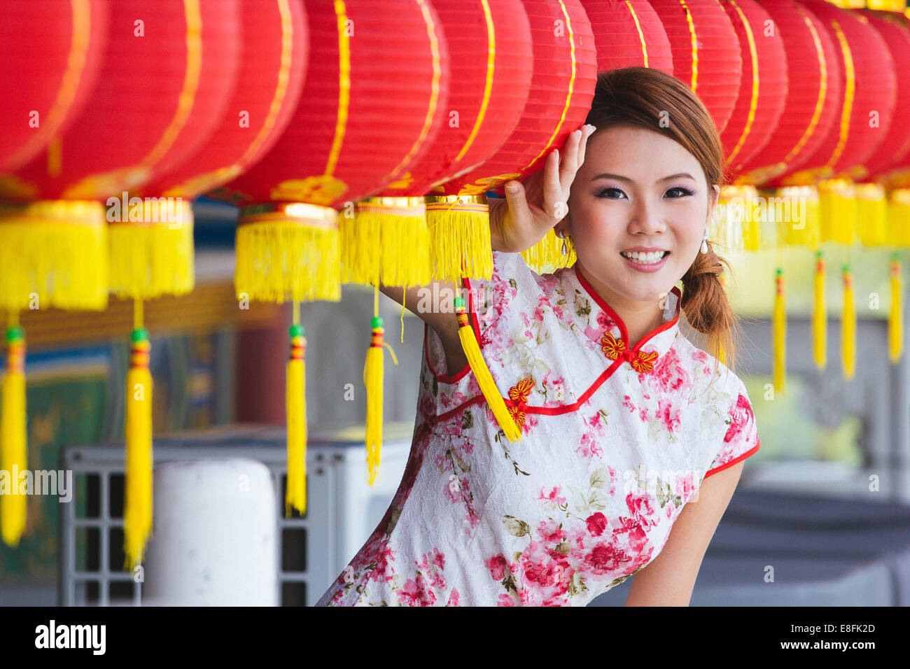 Portrait of young woman standing by Chinese paper lanterns Stock Photo