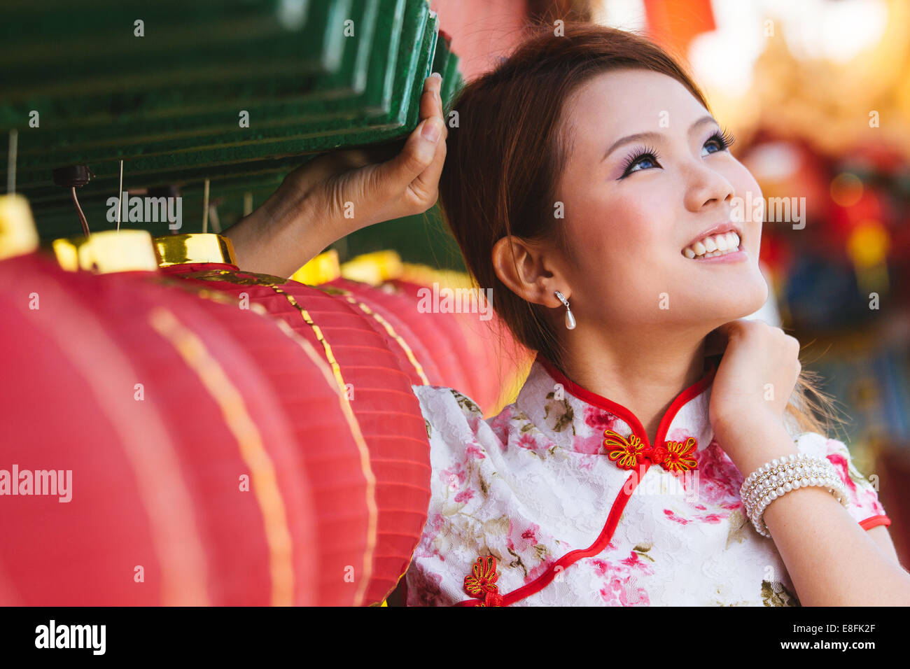 Portrait of young woman standing by Chinese paper lanterns Stock Photo