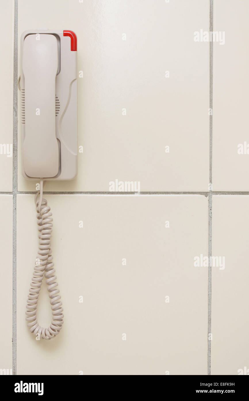 Malaysia, White phone hanging on wall Stock Photo