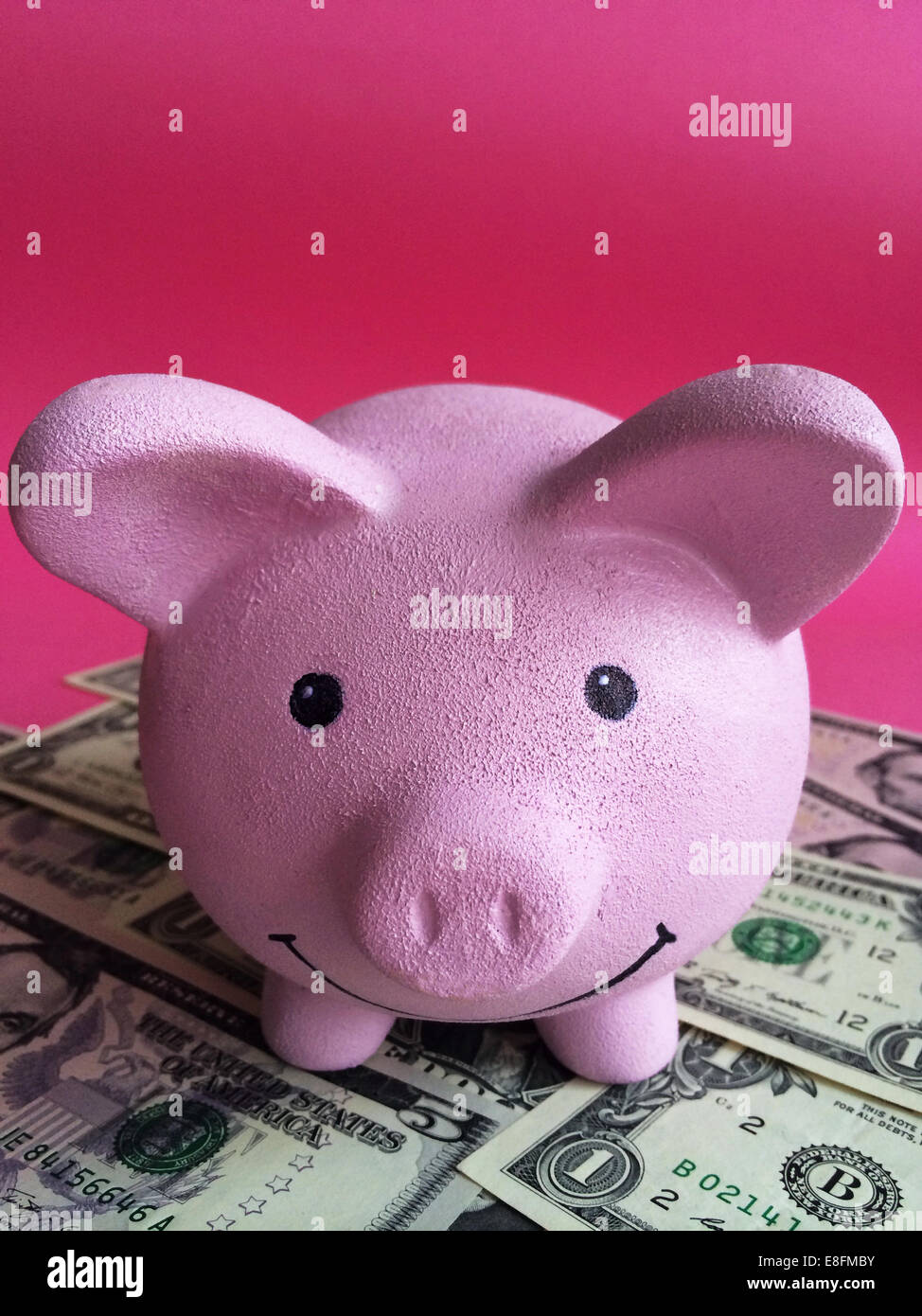 Close-up of pink piggy bank with dollar bills Stock Photo - Alamy