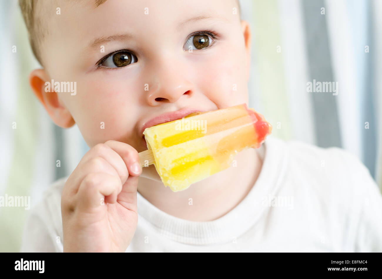 Baby boy eating ice lolly Stock Photo