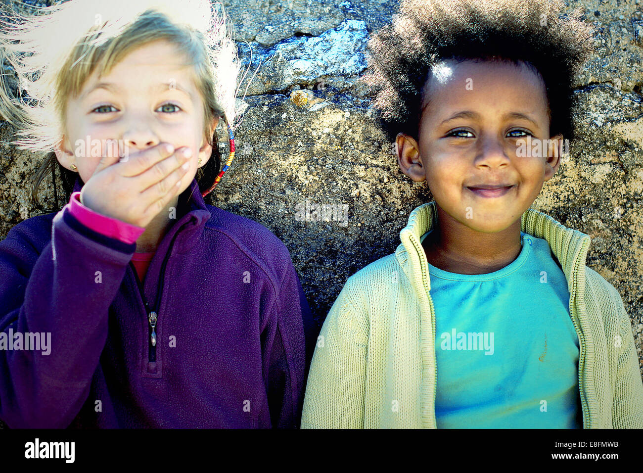 Portrait of two girls standing by a wall Stock Photo - Alamy