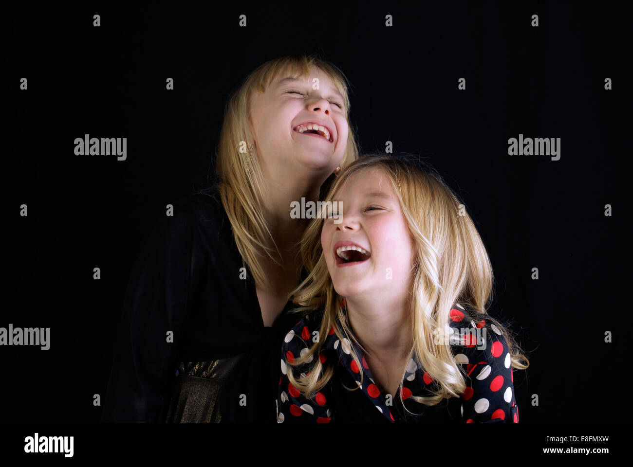 Studio shot of two Sisters (12-13, 16-17) laughing Stock Photo