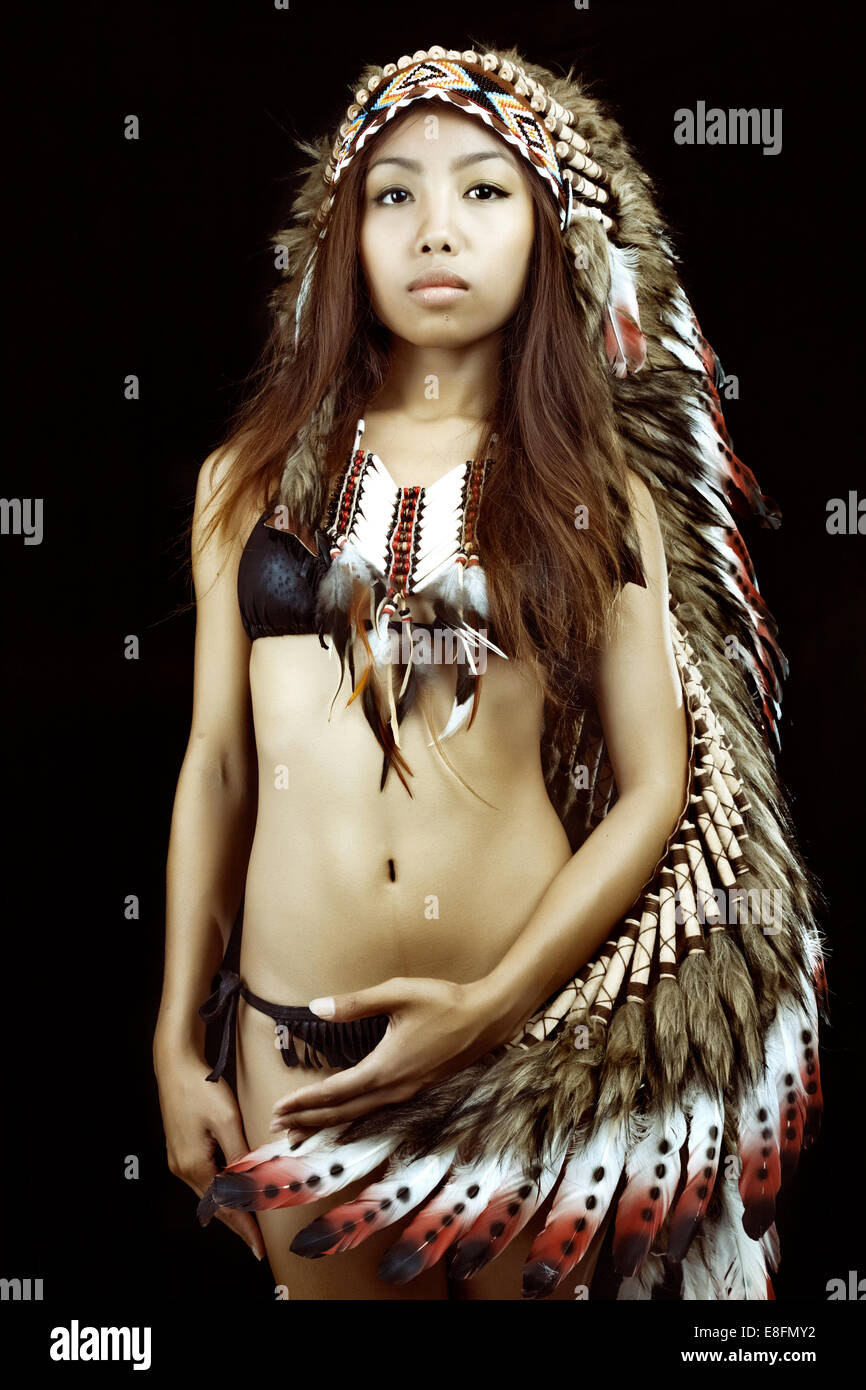 Studio portrait of woman wearing Native American headdress Stock Photo