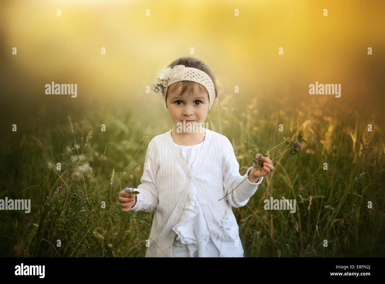 Portrait of a girl standing in a meadow Stock Photo - Alamy