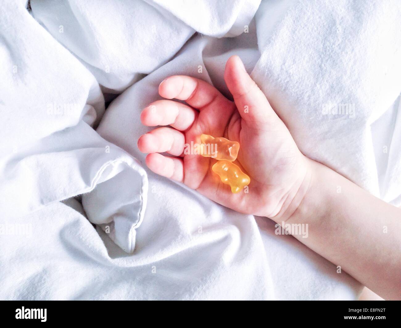 Boy holding teddy bear wine gums in his hand Stock Photo - Alamy