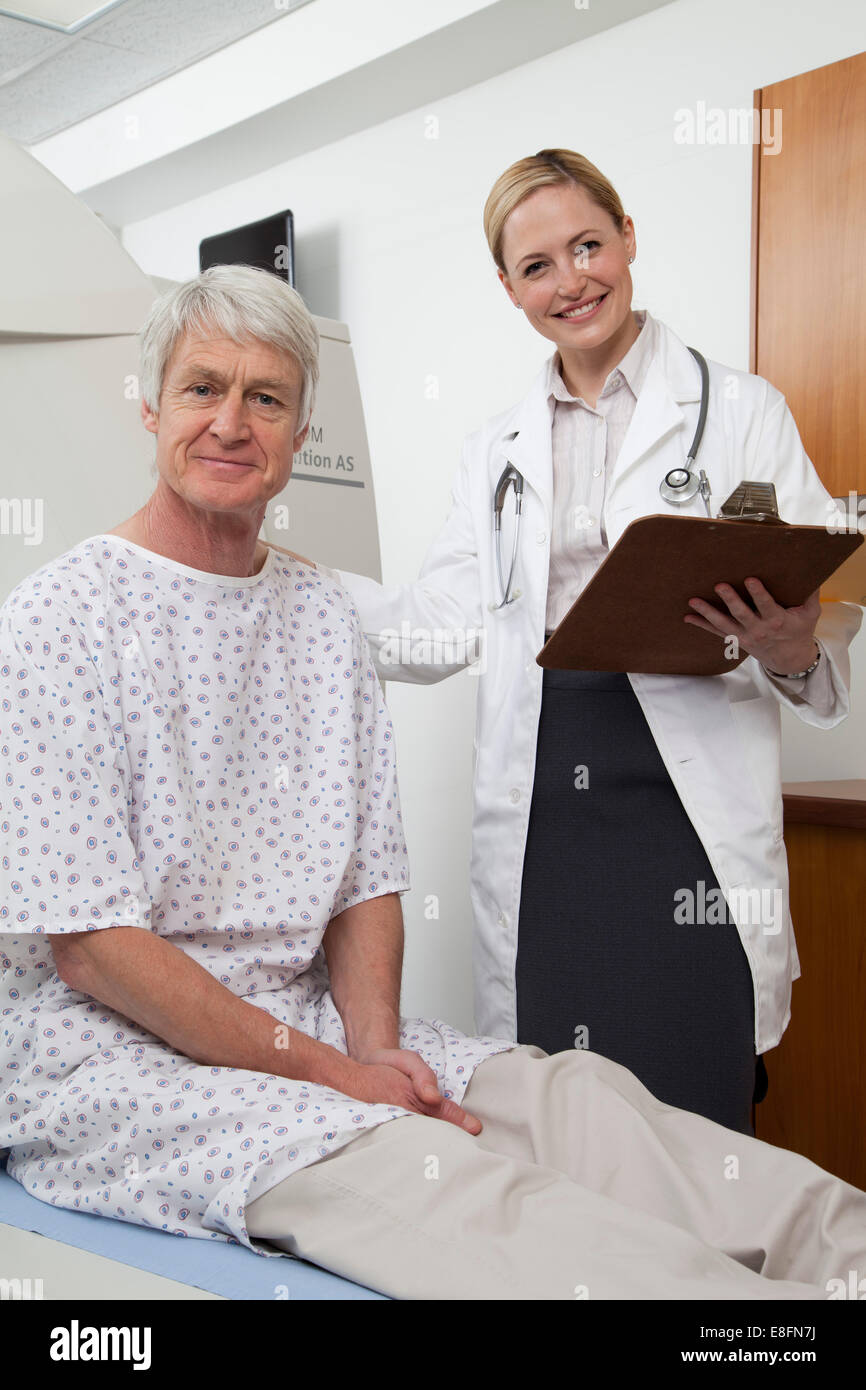 Female doctor and male patient in hospital scanning room Stock Photo