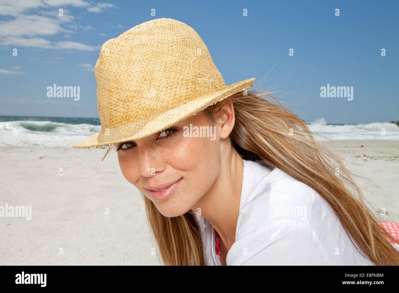 Portrait of smiling woman on beach in straw hat, Cape Town, South Africa Stock Photo