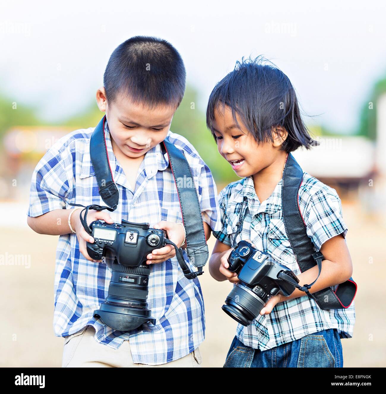 Two boys taking photos on dSLR cameras, New Delhi, India Stock Photo